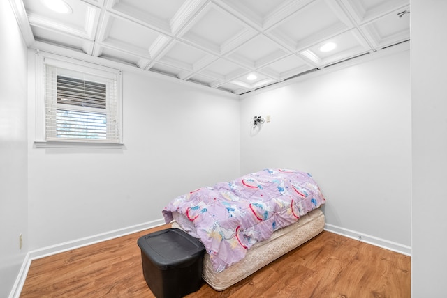 bedroom with beamed ceiling, ornamental molding, coffered ceiling, and hardwood / wood-style flooring