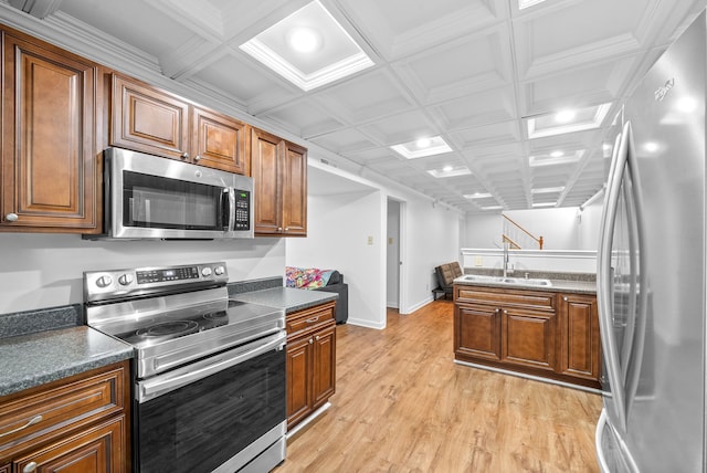 kitchen featuring appliances with stainless steel finishes, light wood-type flooring, coffered ceiling, sink, and beam ceiling