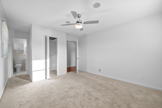 unfurnished bedroom with light colored carpet, ceiling fan, and ensuite bathroom