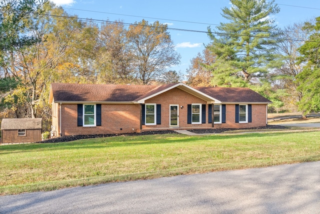 ranch-style home featuring a storage shed and a front yard