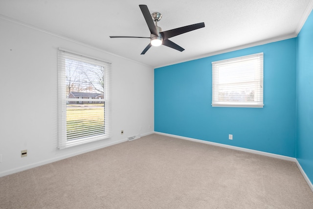 unfurnished room with crown molding, plenty of natural light, and carpet