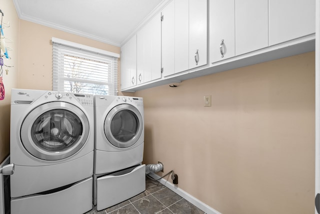 clothes washing area with cabinets, dark tile patterned flooring, washer and dryer, and ornamental molding