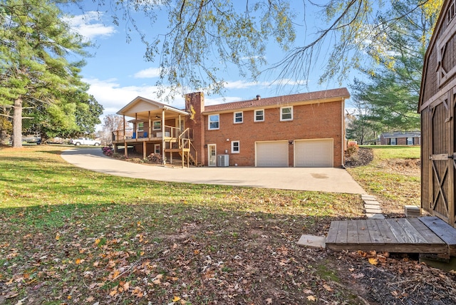 rear view of house with a garage, central AC unit, a lawn, and a wooden deck