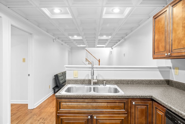 kitchen with coffered ceiling, sink, stainless steel dishwasher, ornamental molding, and light wood-type flooring