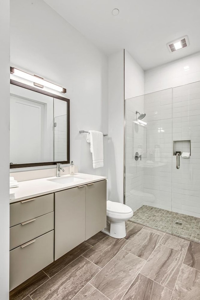 bathroom with vanity, toilet, wood-type flooring, and walk in shower