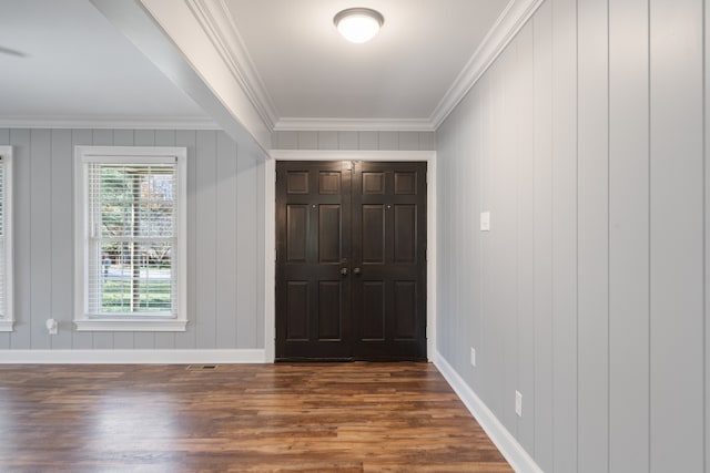 foyer entrance with wooden walls, dark hardwood / wood-style floors, and ornamental molding