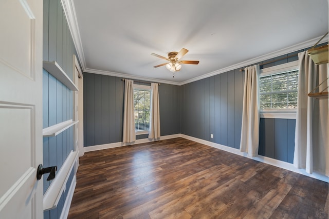 spare room featuring plenty of natural light, crown molding, and dark wood-type flooring