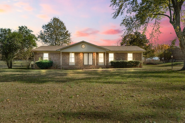 ranch-style home with a lawn