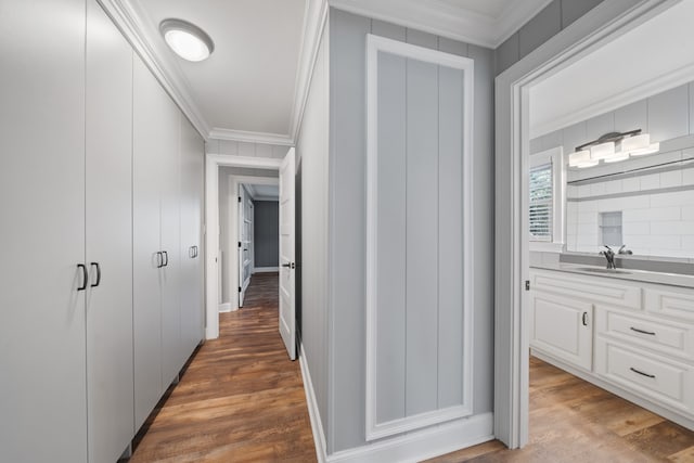 hall with dark hardwood / wood-style floors, ornamental molding, and sink