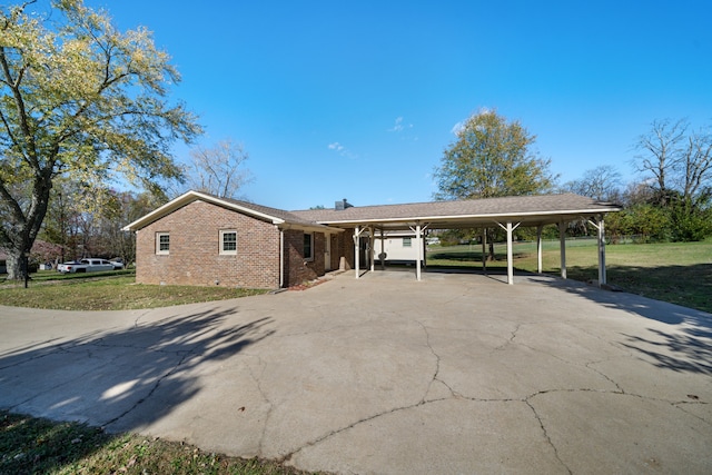 view of front of home with a front yard and a carport