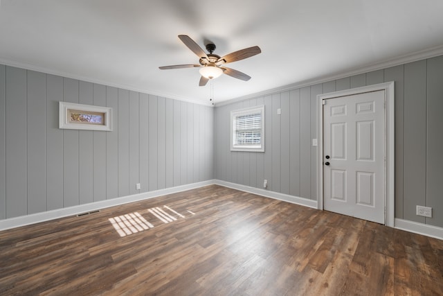 unfurnished room featuring ornamental molding, ceiling fan, and dark wood-type flooring