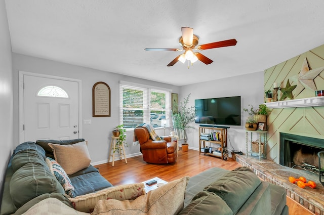 living room with a fireplace, hardwood / wood-style floors, and ceiling fan