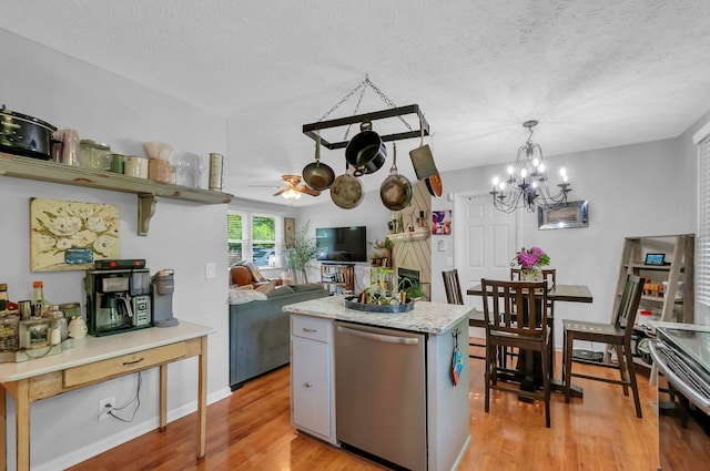 kitchen with ceiling fan with notable chandelier, a textured ceiling, appliances with stainless steel finishes, and light hardwood / wood-style flooring