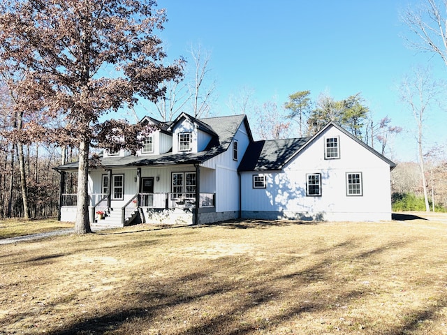 back of house featuring covered porch and a lawn