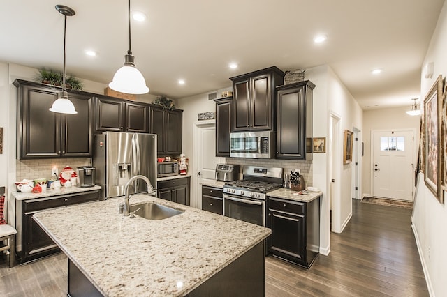 kitchen featuring sink, hanging light fixtures, dark hardwood / wood-style flooring, an island with sink, and appliances with stainless steel finishes