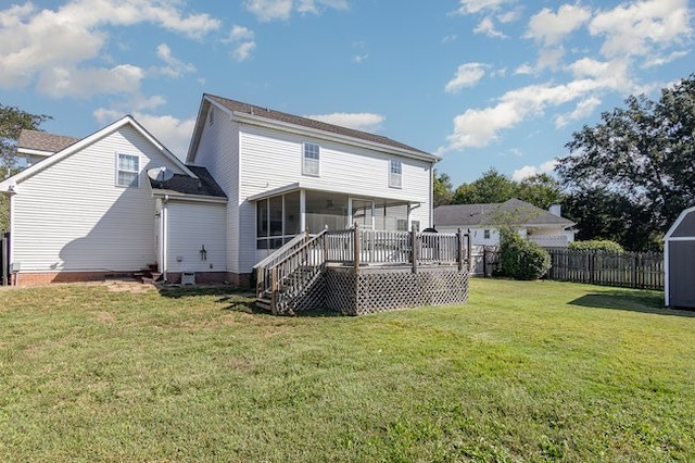 rear view of house with a lawn, a wooden deck, and a sunroom