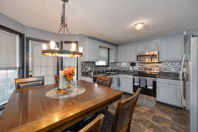 dining space featuring a textured ceiling and a notable chandelier