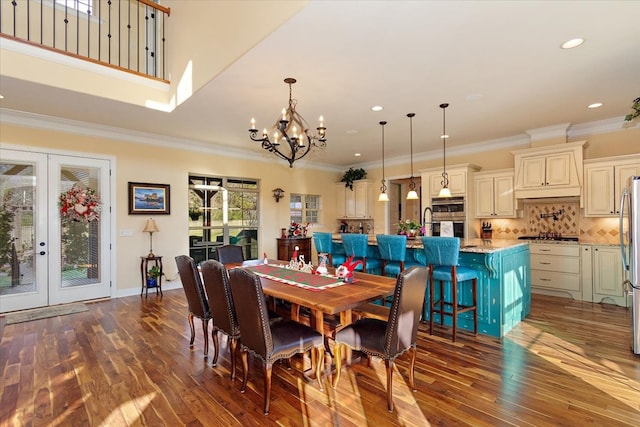 dining room with a chandelier, ornamental molding, dark wood-type flooring, and french doors