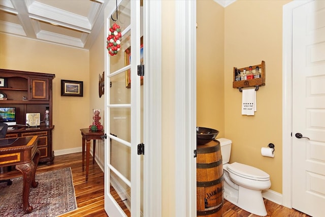 bathroom with beamed ceiling, hardwood / wood-style floors, toilet, and coffered ceiling