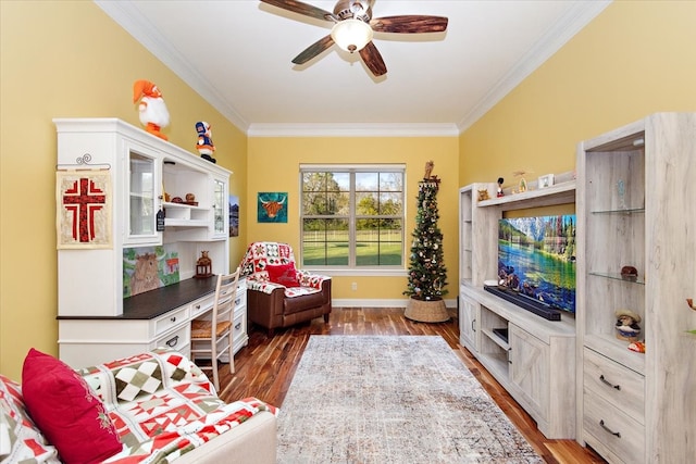 sitting room featuring ceiling fan, crown molding, and dark wood-type flooring