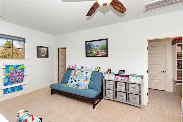 sitting room with ceiling fan and light colored carpet