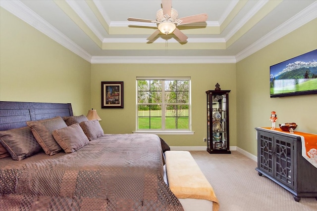 bedroom featuring ceiling fan, ornamental molding, light carpet, and a tray ceiling