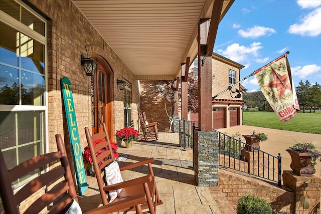 view of patio / terrace featuring a porch and a garage