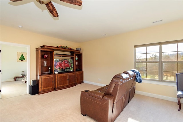 carpeted living room with ceiling fan