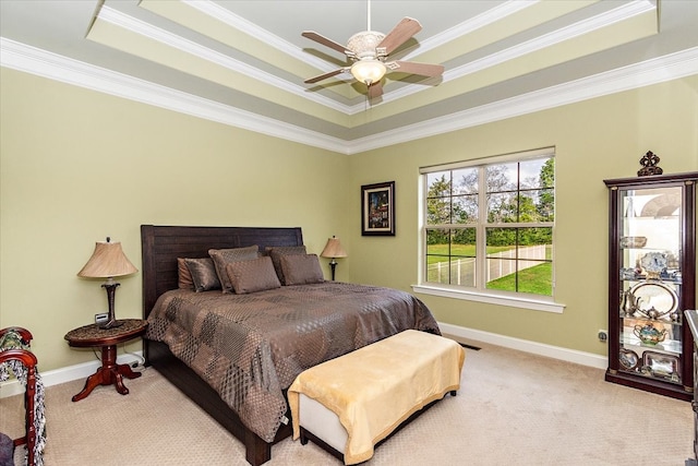 bedroom featuring ceiling fan, ornamental molding, and a tray ceiling