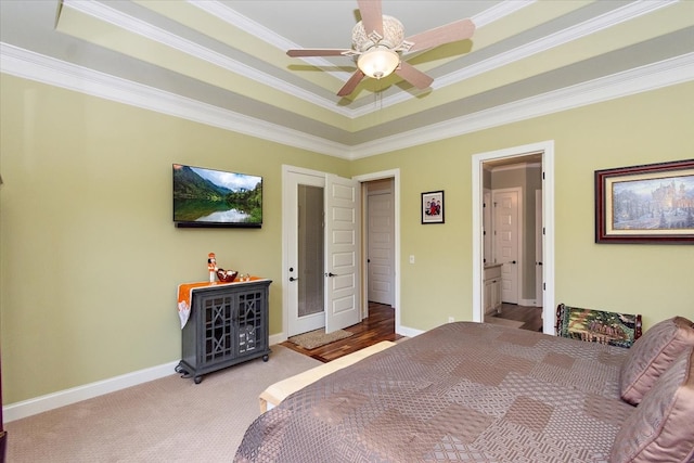 bedroom with ceiling fan, crown molding, connected bathroom, and a tray ceiling