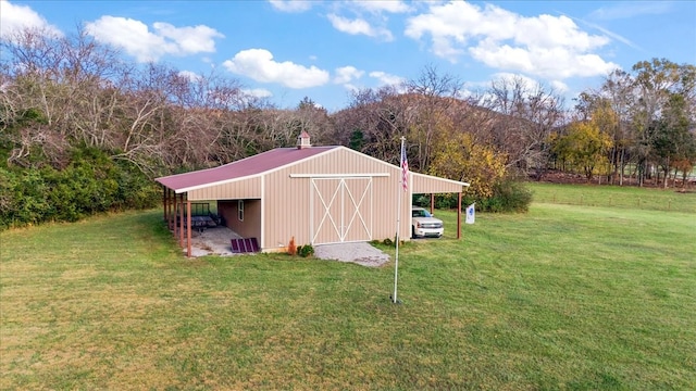 view of outdoor structure with a yard and a carport