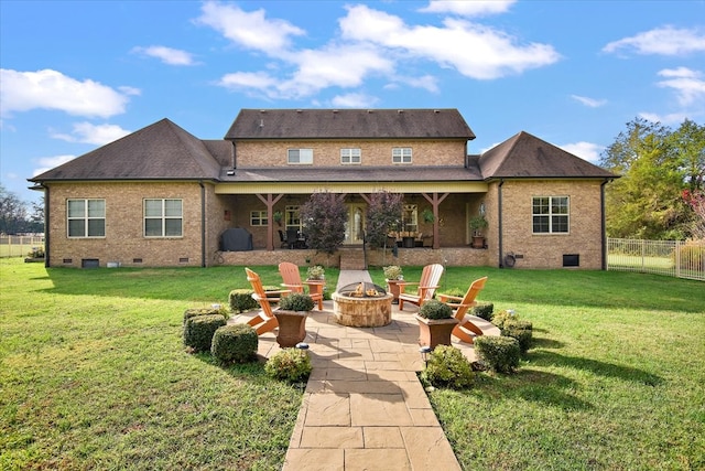 rear view of house featuring an outdoor fire pit, a patio area, and a lawn