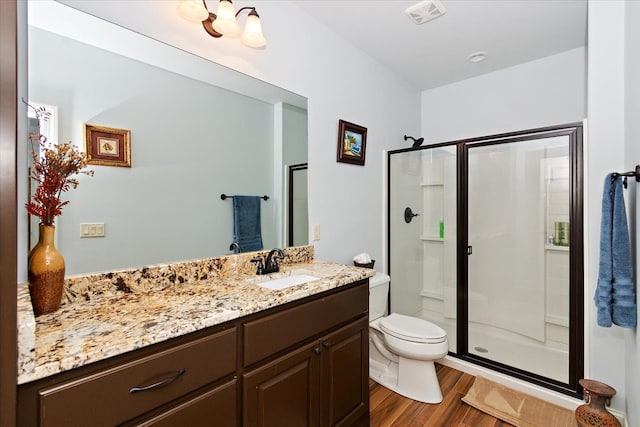 bathroom featuring vanity, wood-type flooring, and walk in shower