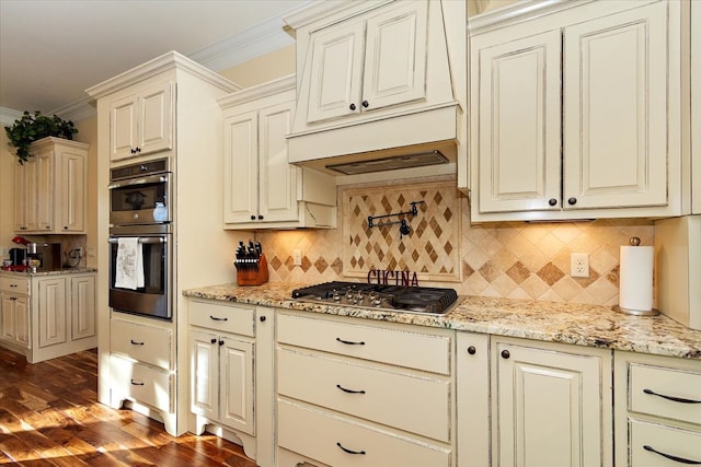 kitchen with decorative backsplash, appliances with stainless steel finishes, light stone countertops, dark wood-type flooring, and crown molding