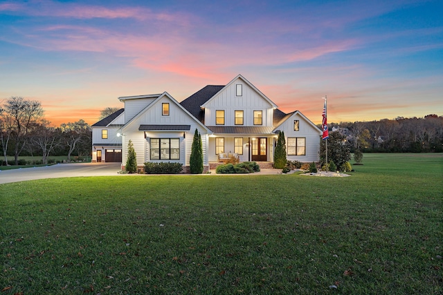 modern farmhouse style home featuring a lawn, a porch, and a garage