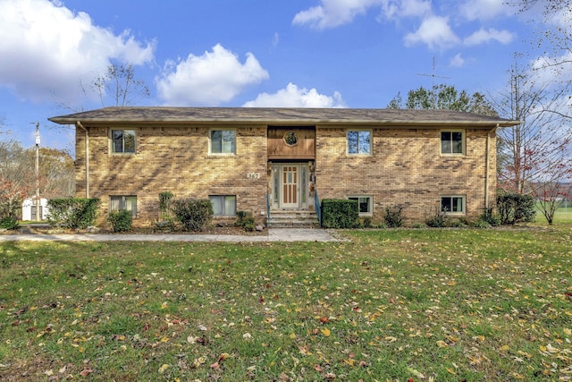 raised ranch featuring a front lawn and brick siding