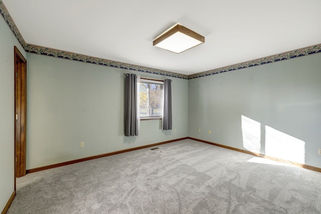 unfurnished room featuring baseboards, visible vents, and carpet flooring