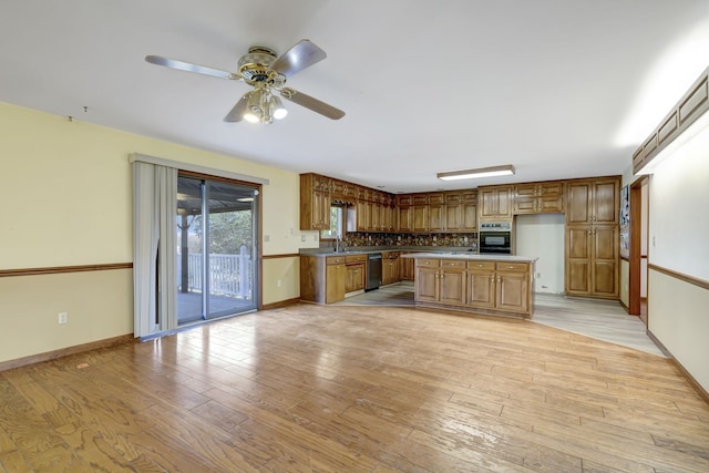 kitchen with ceiling fan, a center island, sink, light hardwood / wood-style floors, and black appliances