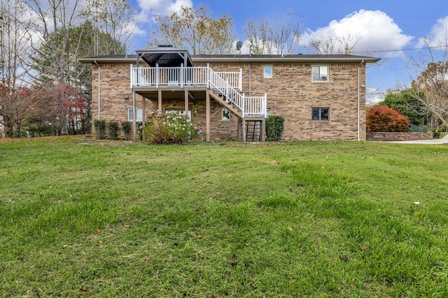 back of property with stairs, a yard, brick siding, and a wooden deck