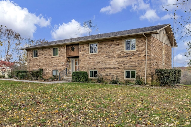 bi-level home with brick siding and a front lawn