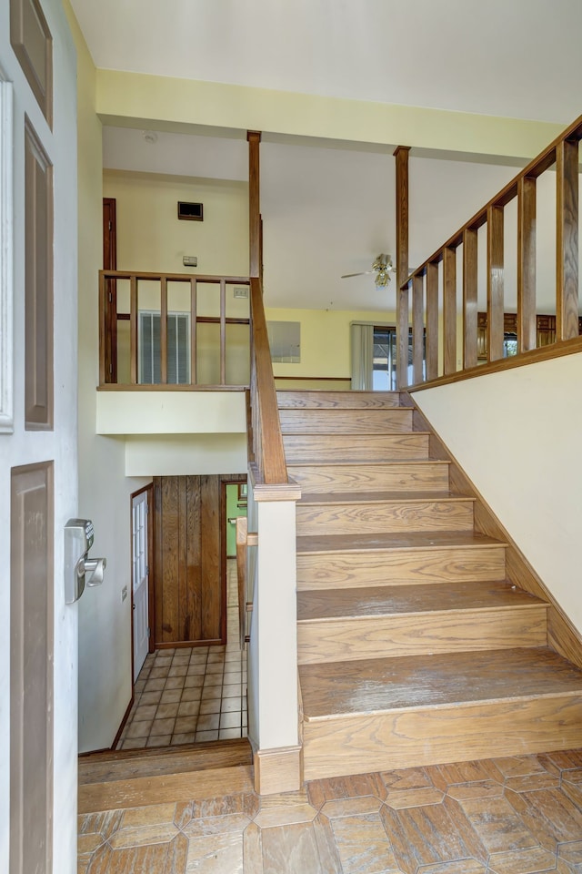 stairs featuring ceiling fan