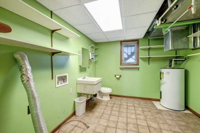 bathroom featuring a paneled ceiling, toilet, and water heater