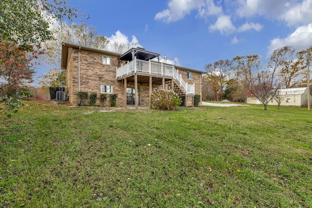 rear view of house featuring stairway, a deck, a lawn, and brick siding