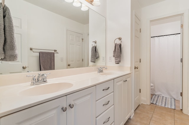 bathroom featuring tile patterned flooring, vanity, and toilet