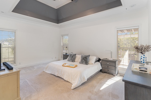 bedroom featuring light carpet, a high ceiling, a tray ceiling, and crown molding