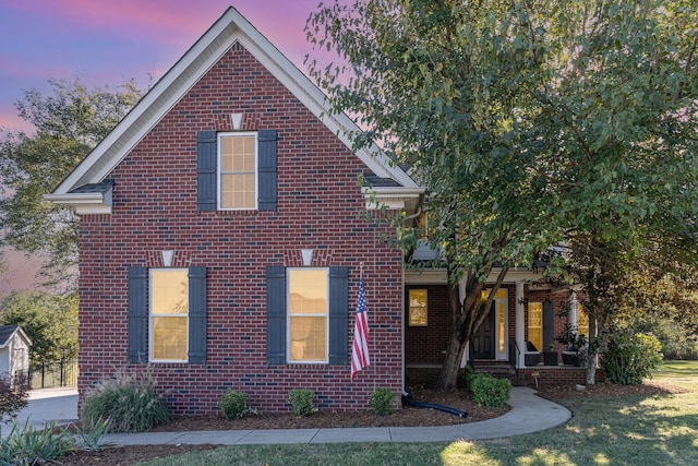 view of front of home with a lawn and a porch