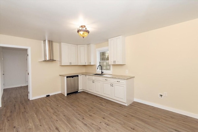 kitchen with white cabinets, wall chimney exhaust hood, sink, light hardwood / wood-style flooring, and dishwasher