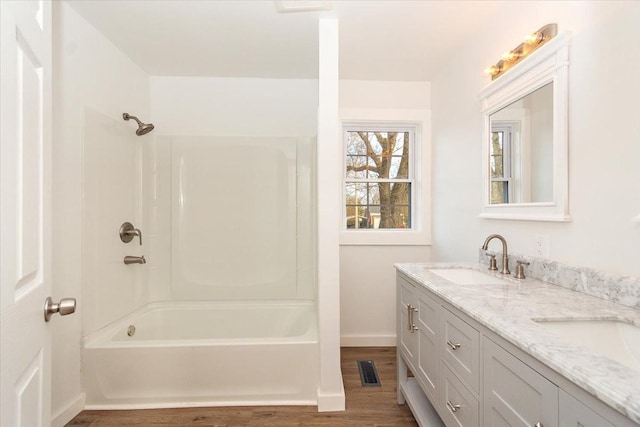 bathroom with hardwood / wood-style floors, vanity, and shower / washtub combination