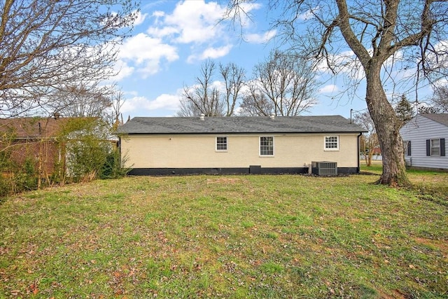 rear view of property featuring a lawn and central AC unit