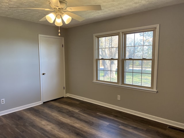 unfurnished room featuring a textured ceiling, ceiling fan, and dark wood-type flooring